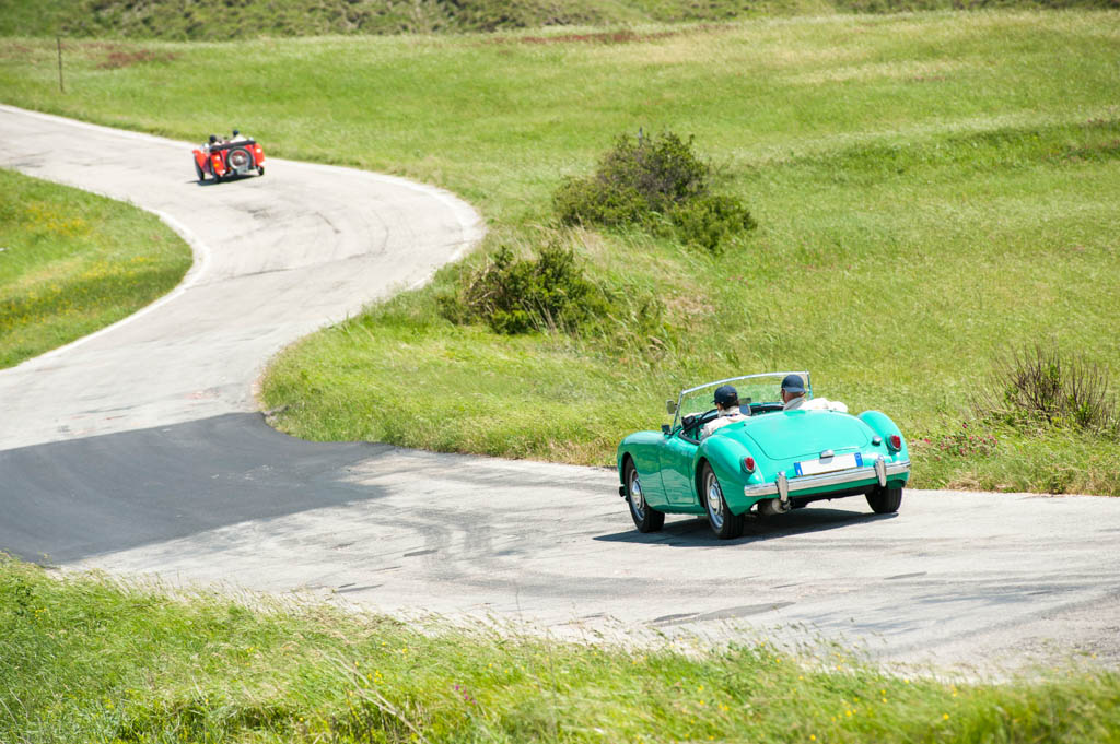 Vintage cars on winding road, Italy