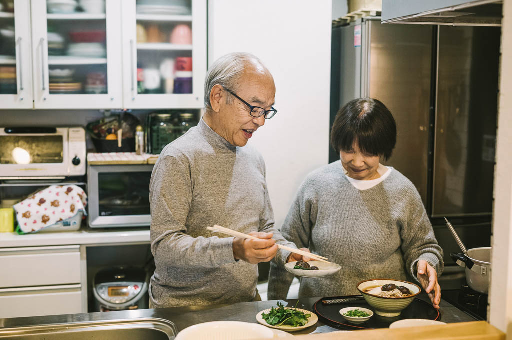 Elderly Japanese couple making toshikoshi soba noodle soup for New Year's celebrations.