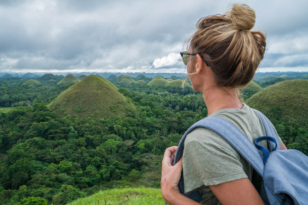 Girl traveling contemplates Chocolate Hills of Bohol, Philippines The Chocolate Hills are a geological formation in the Bohol province of the Philippines. People travel Asia concept vacations