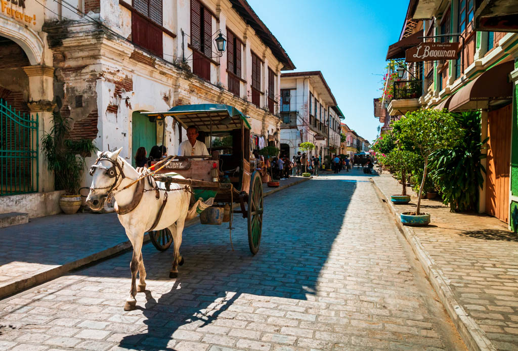 Vigan, Philippines - February 26, 2012: The local scene with traditional horse carriages in Calle Crisologo of Vigan City in the province of Ilocos, Philippines.
