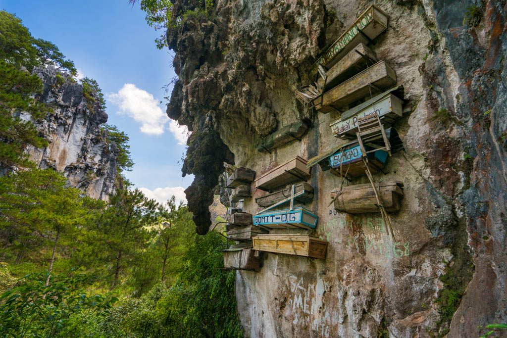 Sagada, Philippines - April 30, 2017: Sagada view showing hanging coffins in the rock mountain and trees can be seen on the background