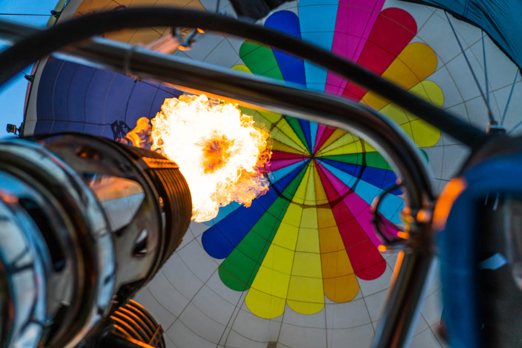 Hot air balloon rising as the flames get bigger under the envelope in the burner