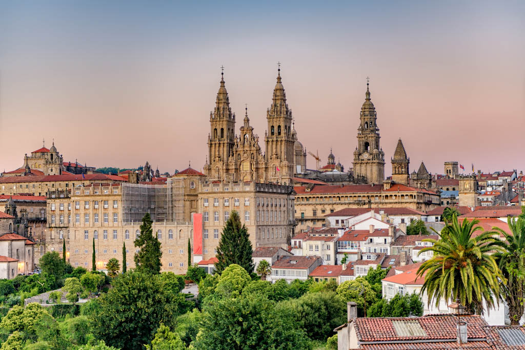 Hazy sunset on monumental Santiago de Compostela cathedral and cityscape.