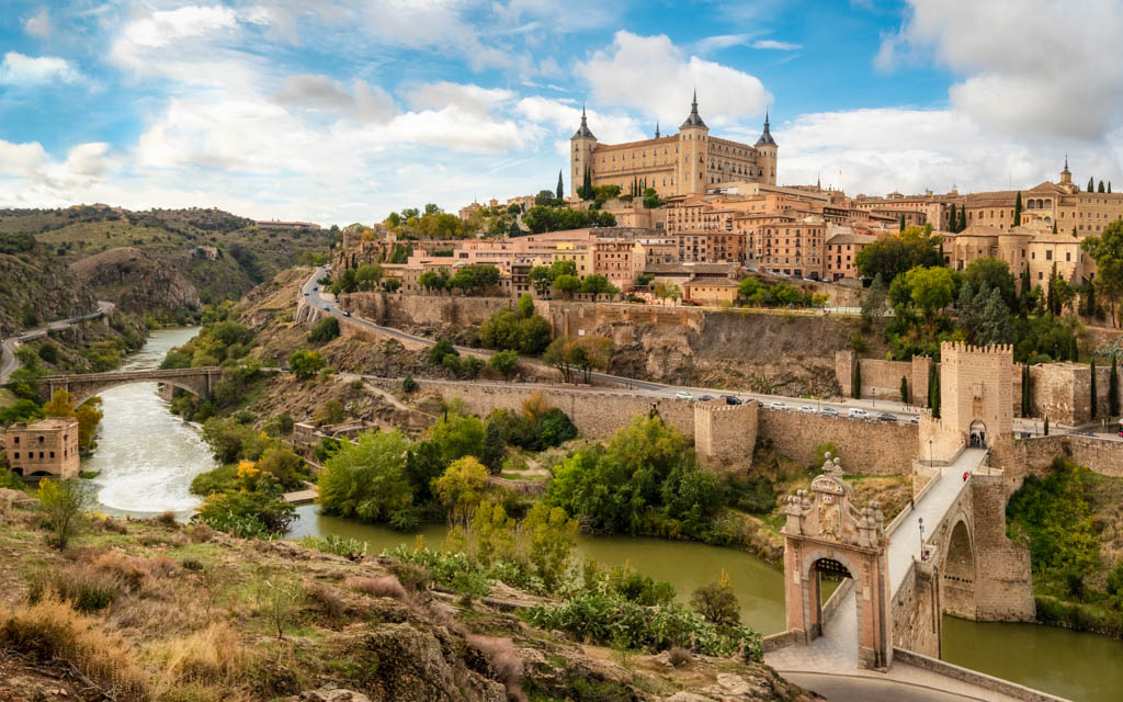Toledo cityscape with Alcantara bridge (Puente de Alcantara) over Targus river. Spain
