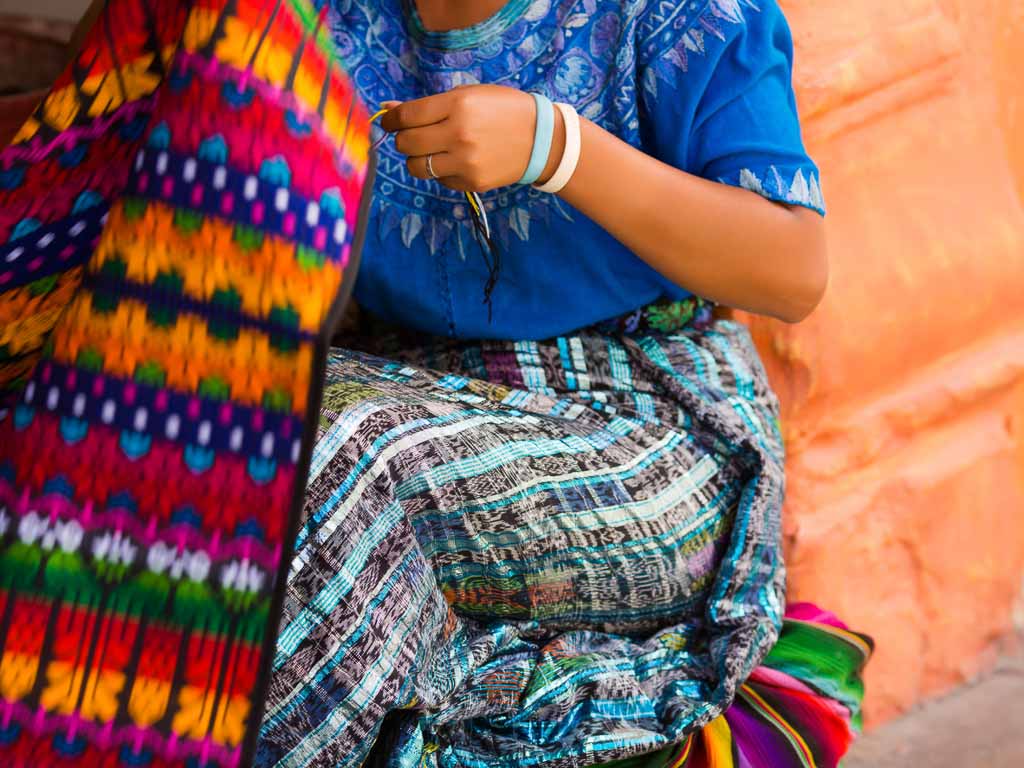 detail of guatemalan mayan woman weaving in the street