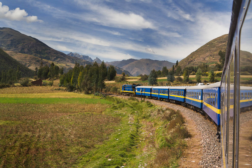 The Peruvian train journey from the city of Cuzco to the Inca ruin of Machu Picchu, along the Andes mountain plains of Peru, South America. The scenic mountainous landscape offers a breathtaking locomotive ride, railroad transportation to a tourist travel destination and famous place.