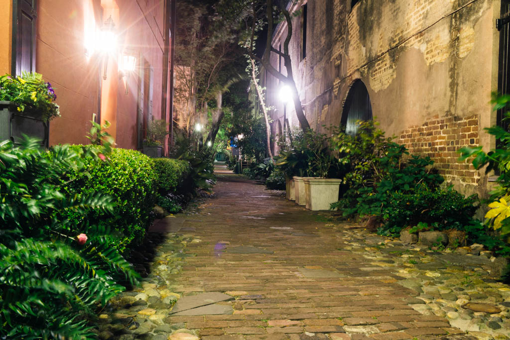 This is a color photograph of historic, Philadelphia Alley at night in the French Quarter of Charleston, South Carolina, a travel destination in the Southern USA.