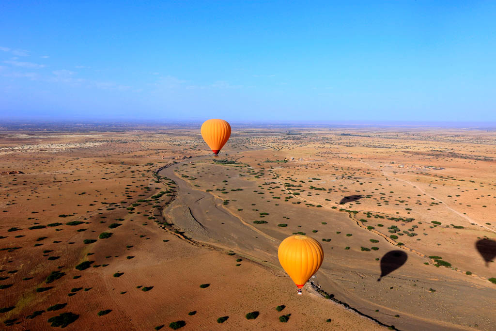 hot air balloon fly over the Marrakesh desert of Agafay in Morocco with blue sky in the background