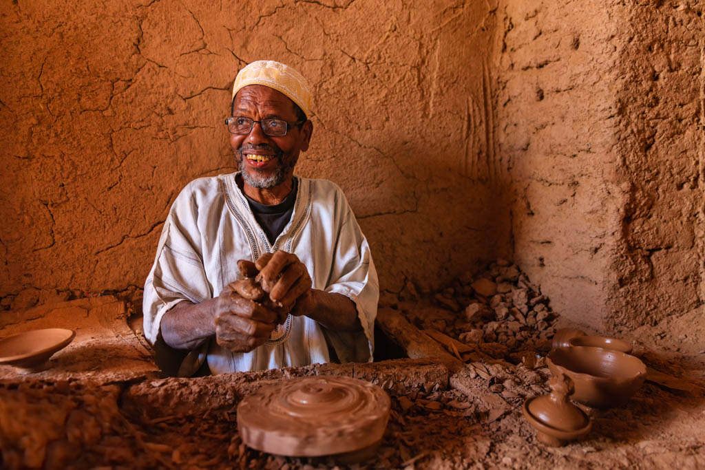 "Moroccan potter working in the workshop on the pottery wheel near Ouarzazate, Morocco."