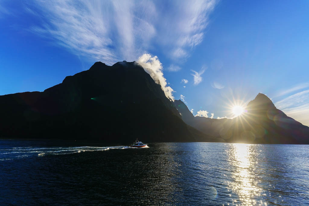 Tour cruise in Fiordland National Park in Milford Sound / Piopiotahi Marine Reserve viewing beautiful sunset and silhouette Mitre Peak , South Island of New Zealand