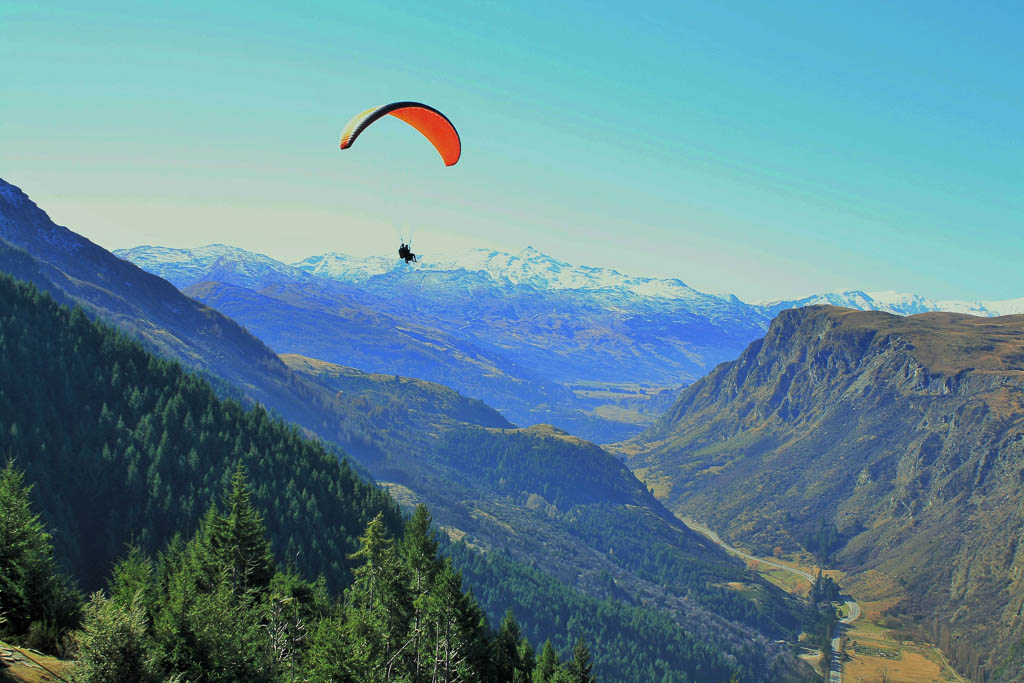 Tandem paragliding from the top of the mountain above Queenstown, New Zealand. Uniterupted view of mountains, Gorge Road and stunning scenery. Taken on a clear winters day.