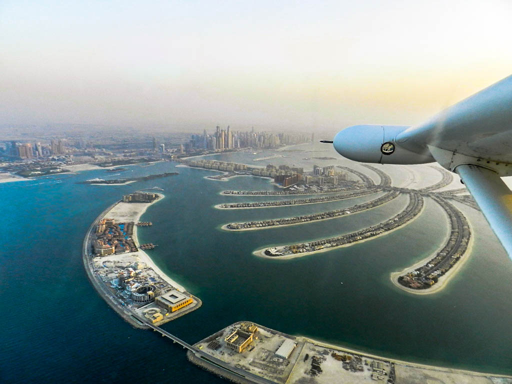 Aerial view of Dubai skyline at the background of the picture and partial view of Jumeirah Palm Island in the foreground, part of the Hydroplane propeller can be seen at the right hand, September 29, 2013