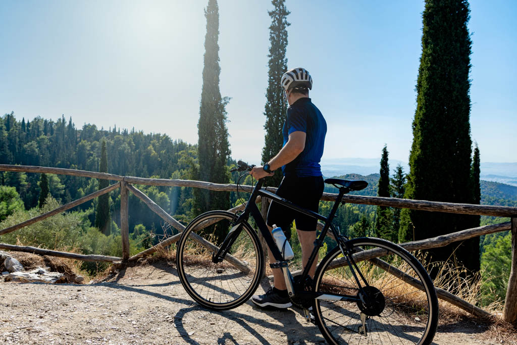 Male cyclist standing with his bike before or after training watching the view