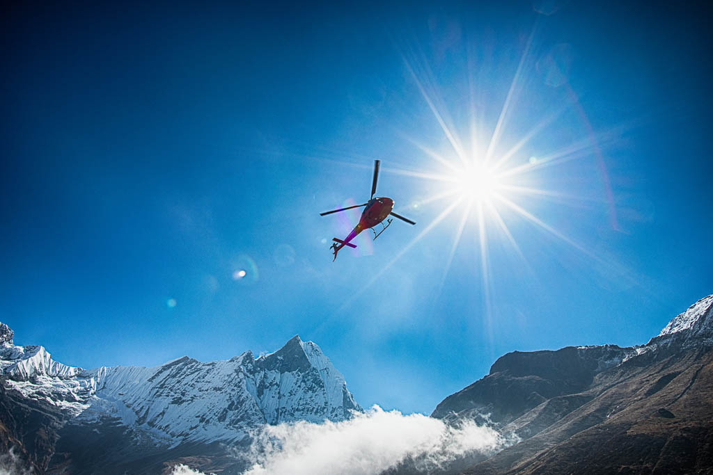 Mt.Machapuchare and helicopter with the sun