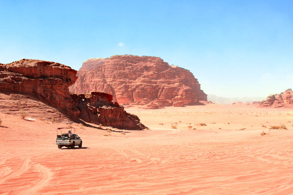Jeep safari in Wadi Rum desert, Jordan. Tourists in the car ride on off-road on sand among the beautiful rocks
