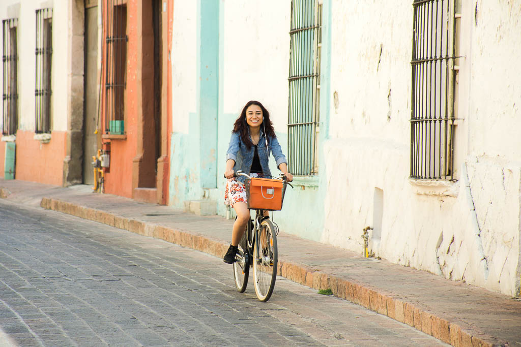 Mujer paseando en bicicleta por la ciudad colonial de Querétaro, México