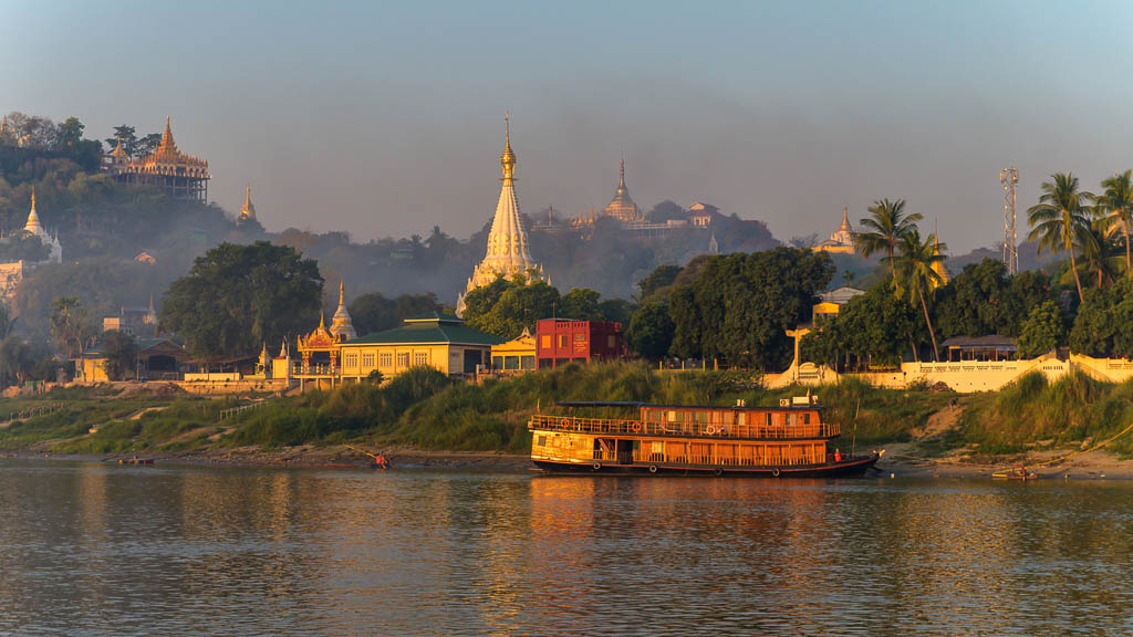 View on the landscape of Myanmar from the Irrawaddy River just after sunrise. Warm colors en lots of pagoda's