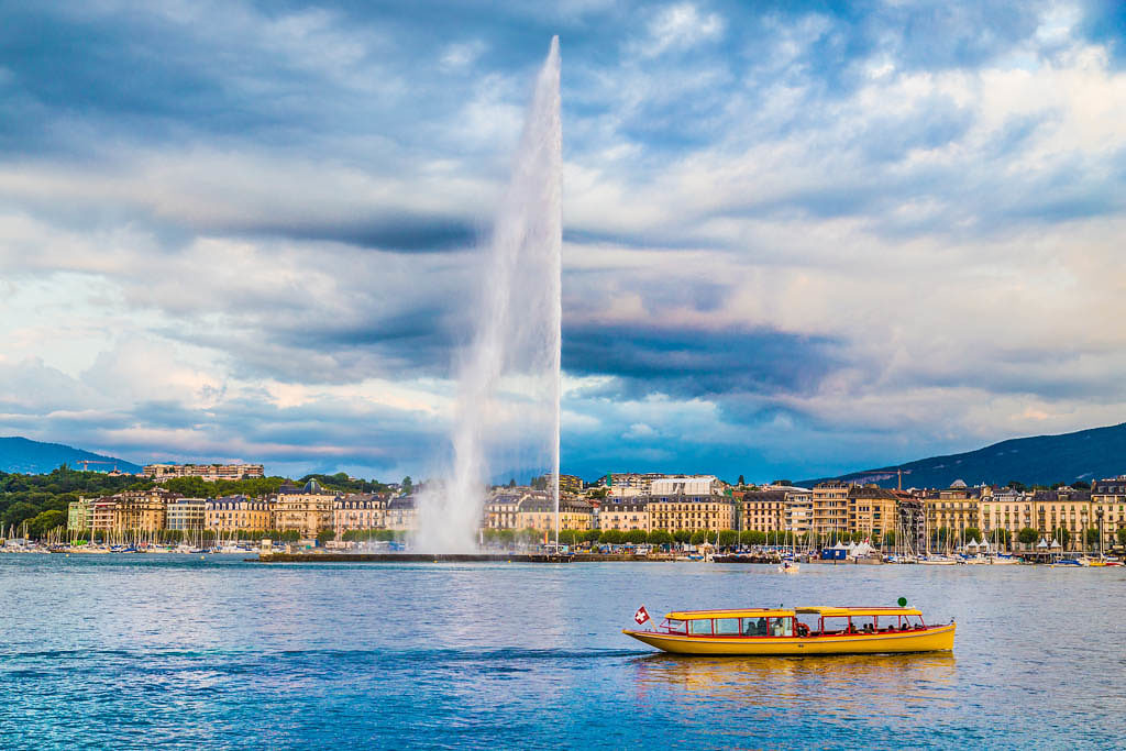 Beautiful view of Geneva skyline with famous Jet d'Eau fountain at harbor district in beautiful evening light, Switzerland.